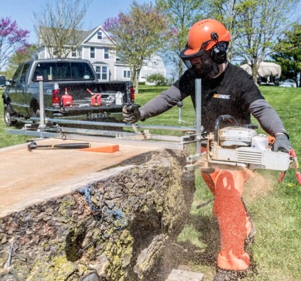 Different view of Man cutting a Log using Granberg Equipment