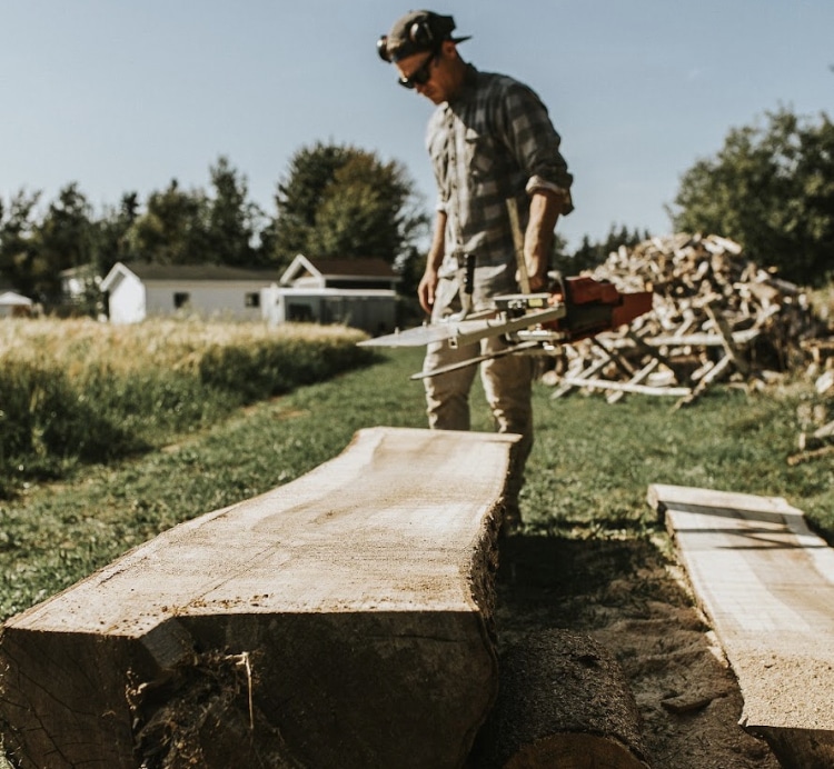 A man doing chainsaw milling.